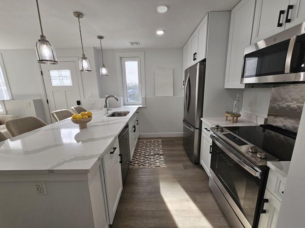 64 Alpine Street, Unit 104 Boston, MA 02119 - Photo 4 of 15 a kitchen with a sink stove and refrigerator