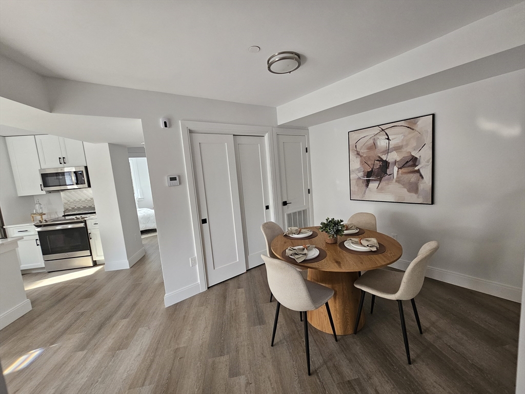 64 Alpine Street, Unit 104 Boston, MA 02119 - Photo 5 of 15 a view of a dining room with furniture and wooden floor
