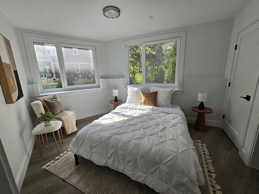 64 Alpine Street, Unit 104 Boston, MA 02119 - Photo 8 of 15 a bedroom with a bed a window and walk in closet