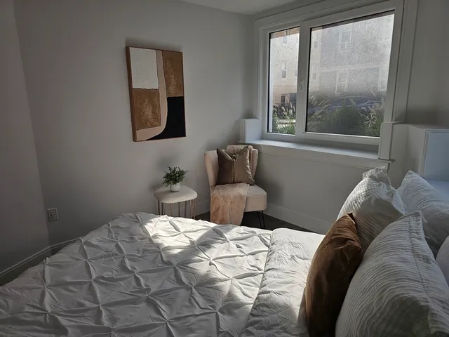 a bedroom with a bed lamp and window