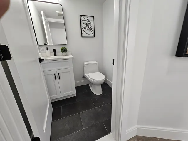 a bathroom with a toilet sink and a mirror