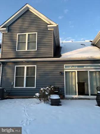 a view of a house with large space and a car parked in front of it
