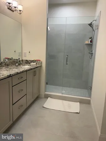 a bathroom with a granite countertop sink a toilet and shower