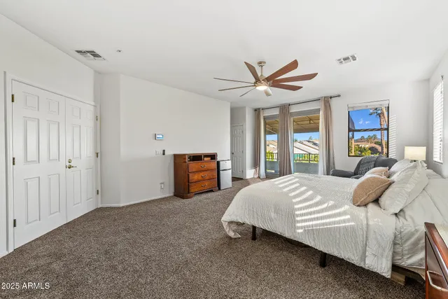 a bedroom with a bed a ceiling fan and a large window