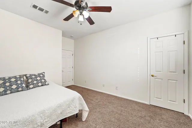 a bedroom with a bed and a chandelier fan