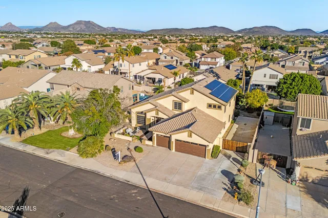 an aerial view of residential houses with outdoor space and trees