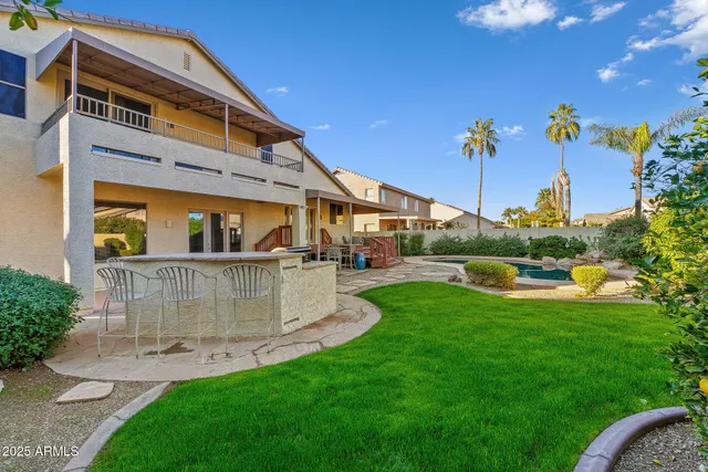 a view of a white house with a yard and palm trees