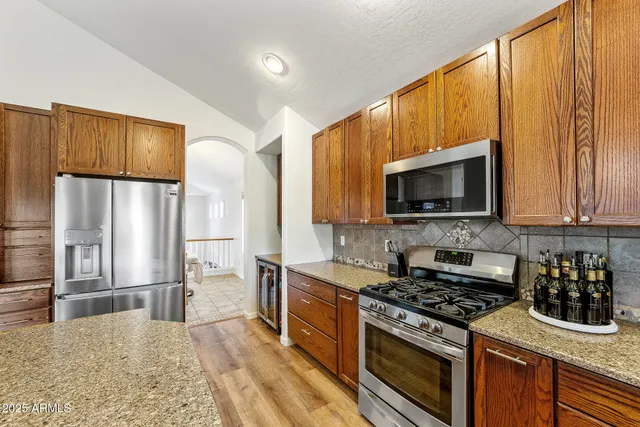 a kitchen with stainless steel appliances granite countertop a stove a sink and a microwave