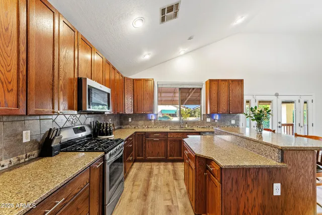 a kitchen with a sink a counter top space cabinets and stainless steel appliances