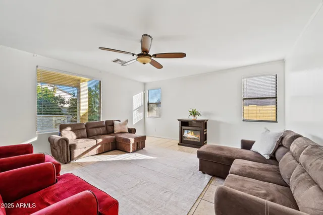 a living room with furniture ceiling fan and a window