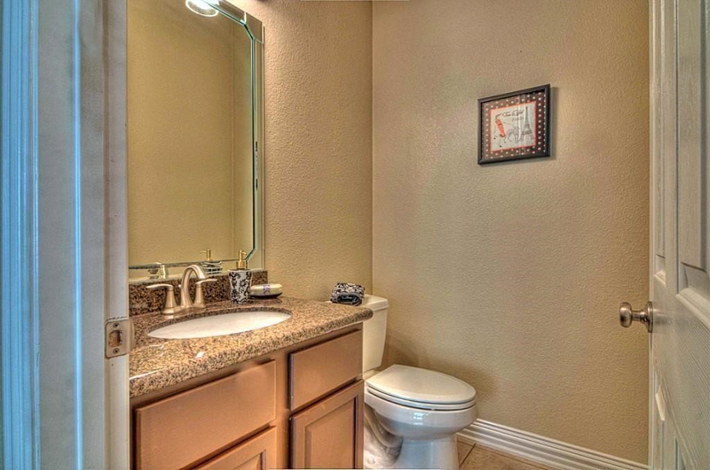 3505 Jackson Street Houston, TX 77004 - Photo 13 of 32 a bathroom with a granite countertop toilet a sink and a mirror