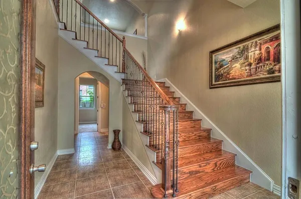 a view of staircase with lots of frames on wall and wooden floor