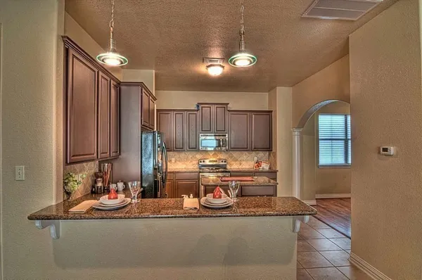 a kitchen with kitchen island granite countertop a sink and cabinets