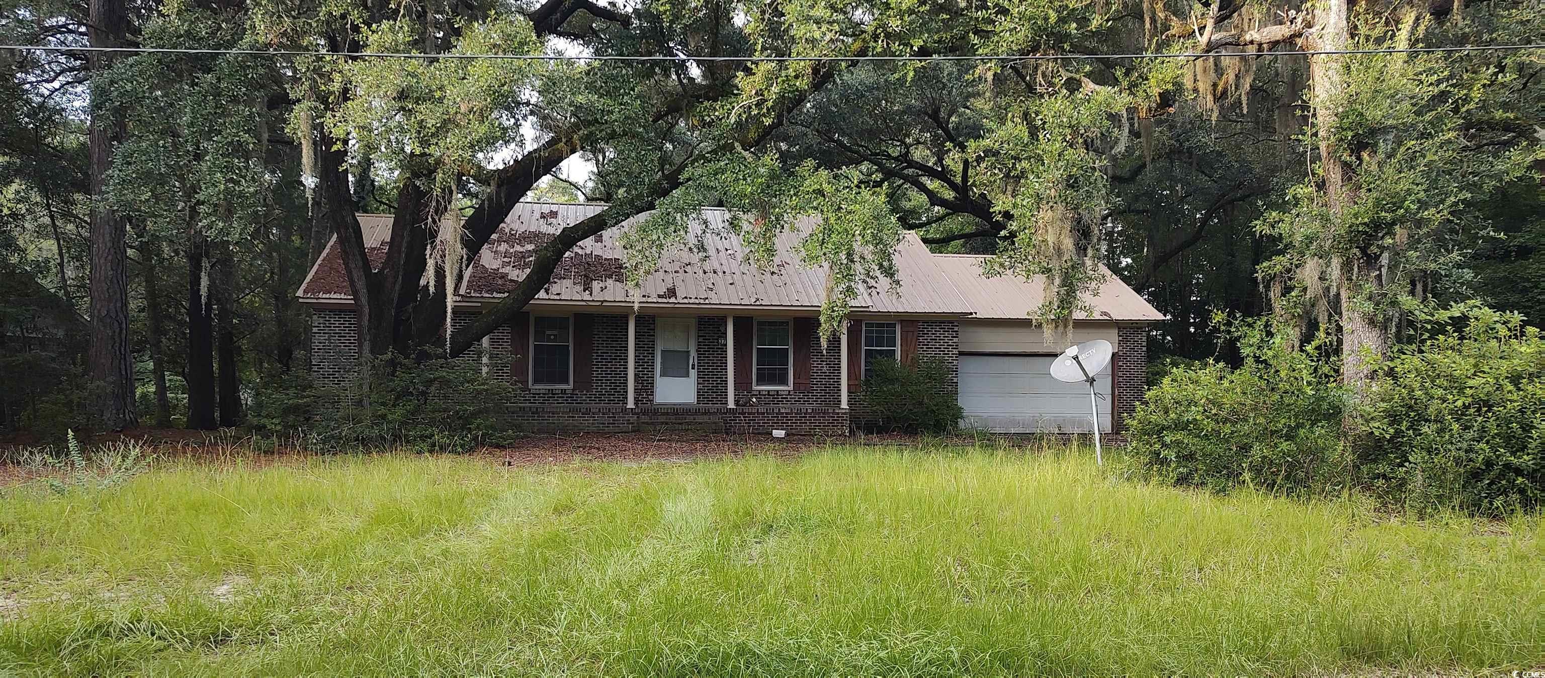 Ranch-style house with a garage and a metal roof