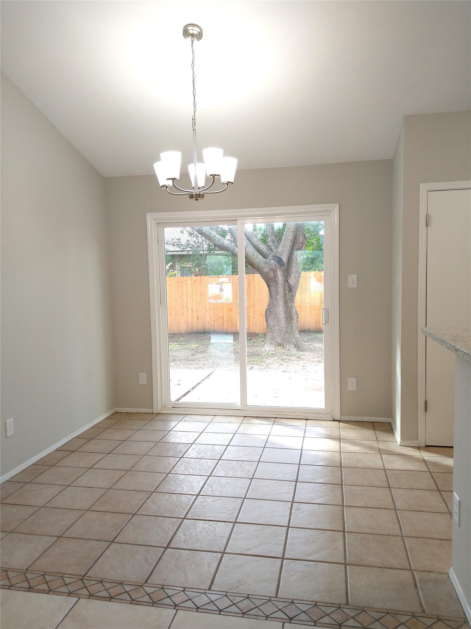 1813 Laurel Path Round Rock, TX 78664 - Photo 10 of 35 A dining area with a modern chandelier and access to the outdoor space through sliding doors.