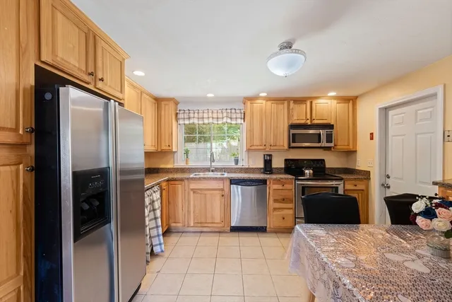a kitchen with stainless steel appliances granite countertop a refrigerator stove top oven and sink