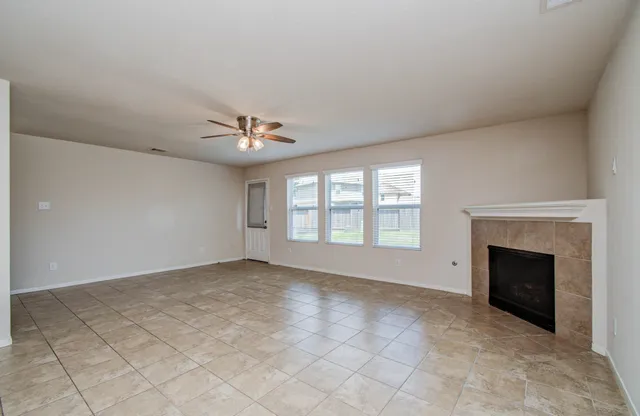a view of an empty room with a fireplace and a window