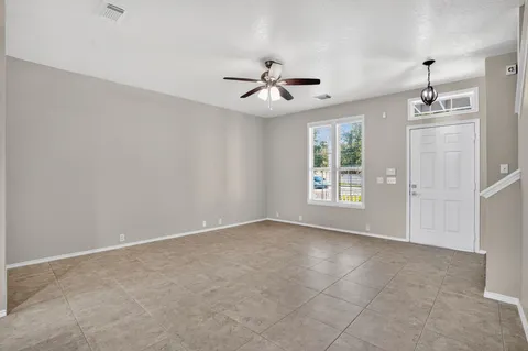 an empty room with windows and fan