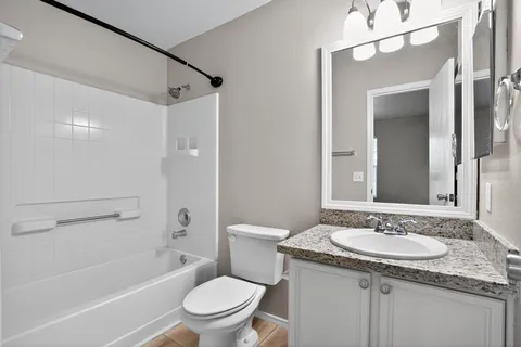 a bathroom with a granite countertop sink toilet and shower
