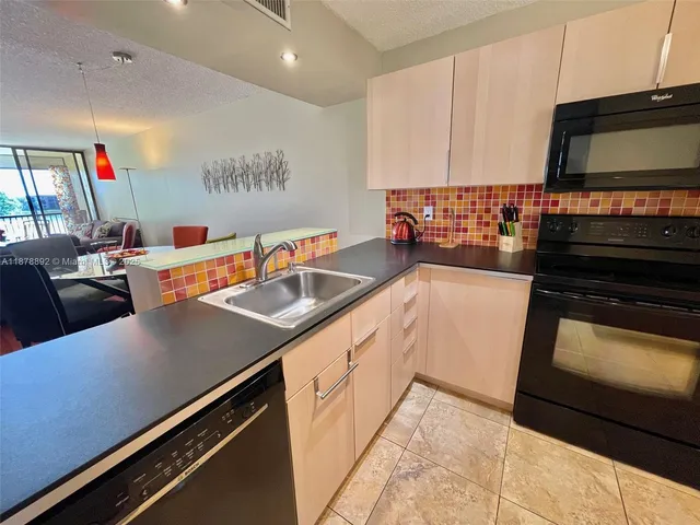 a kitchen with stainless steel appliances a sink dishwasher stove and oven