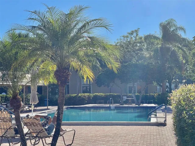a view of backyard with swimming pool and seating