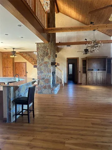 a view of a livingroom with furniture wooden floor a flat screen tv and a chandelier