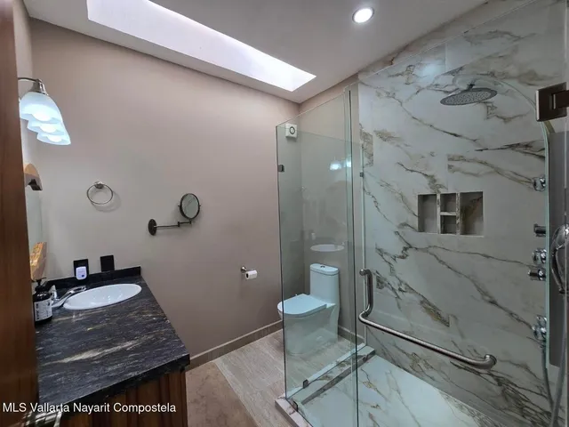 a bathroom with a sink a toilet and shower