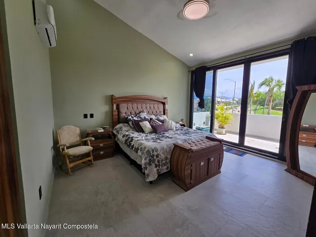 a bedroom with a bed and large windows