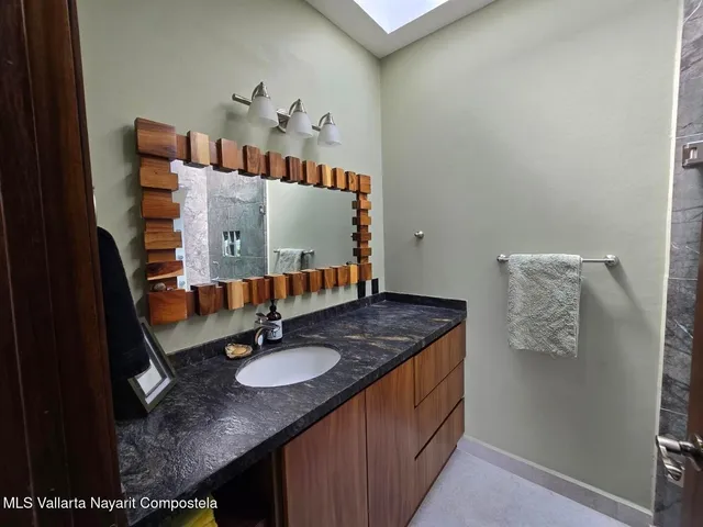 a bathroom with a granite countertop sink and a mirror