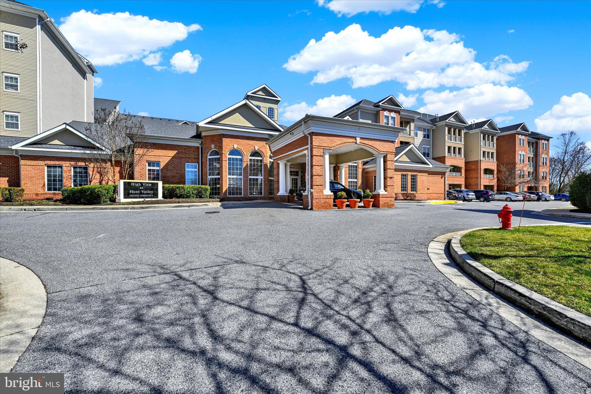 400 Symphony Circle, Unit 414 Hunt Valley, MD 21030 - Photo 1 of 29 a front view of a building with lot of cars parked on road