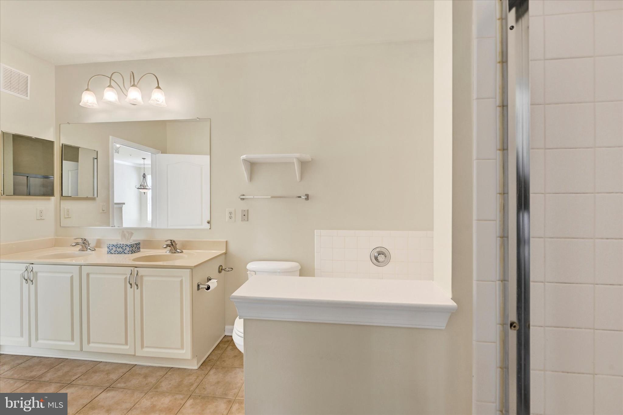400 Symphony Circle, Unit 414 Hunt Valley, MD 21030 - Photo 14 of 29 a bathroom with a sink a large mirror and a shower