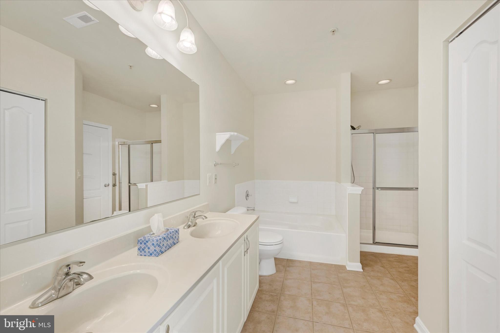 400 Symphony Circle, Unit 414 Hunt Valley, MD 21030 - Photo 18 of 29 a bathroom with a bathtub sink and mirror