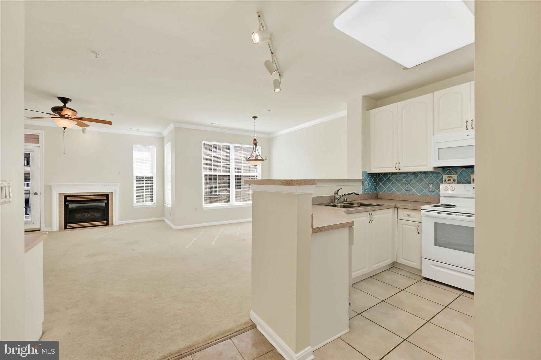 400 Symphony Circle, Unit 414 Hunt Valley, MD 21030 - Photo 2 of 29 a kitchen with granite countertop white cabinets and white appliances