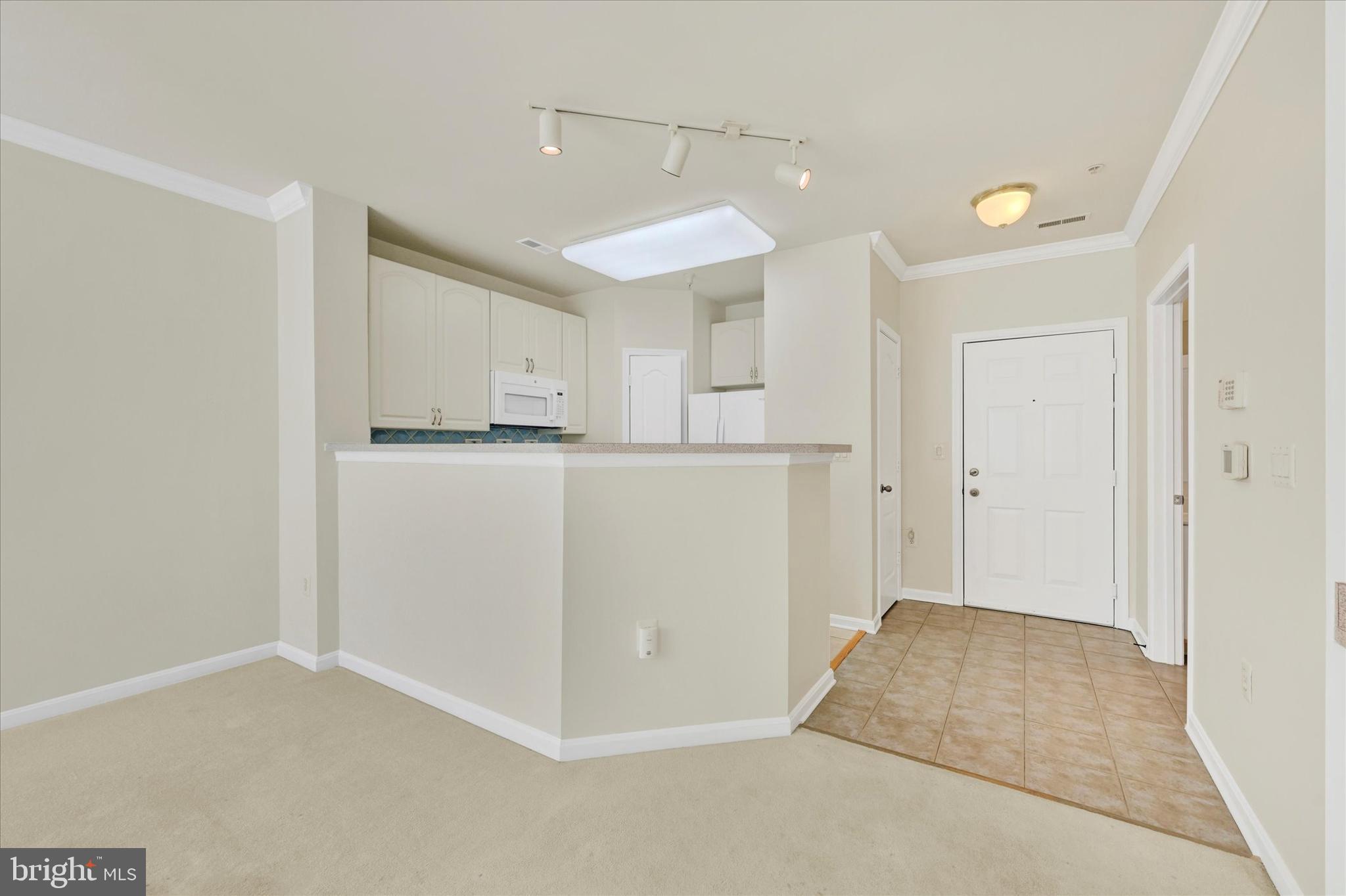 400 Symphony Circle, Unit 414 Hunt Valley, MD 21030 - Photo 3 of 29 a view of a kitchen with refrigerator and white cabinets