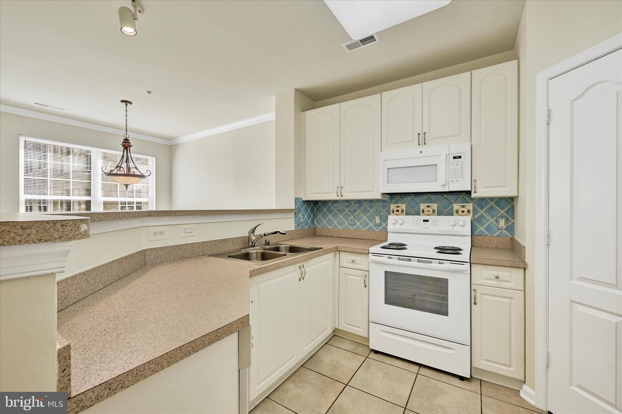 400 Symphony Circle, Unit 414 Hunt Valley, MD 21030 - Photo 6 of 29 a kitchen with a stove white cabinets and white appliances
