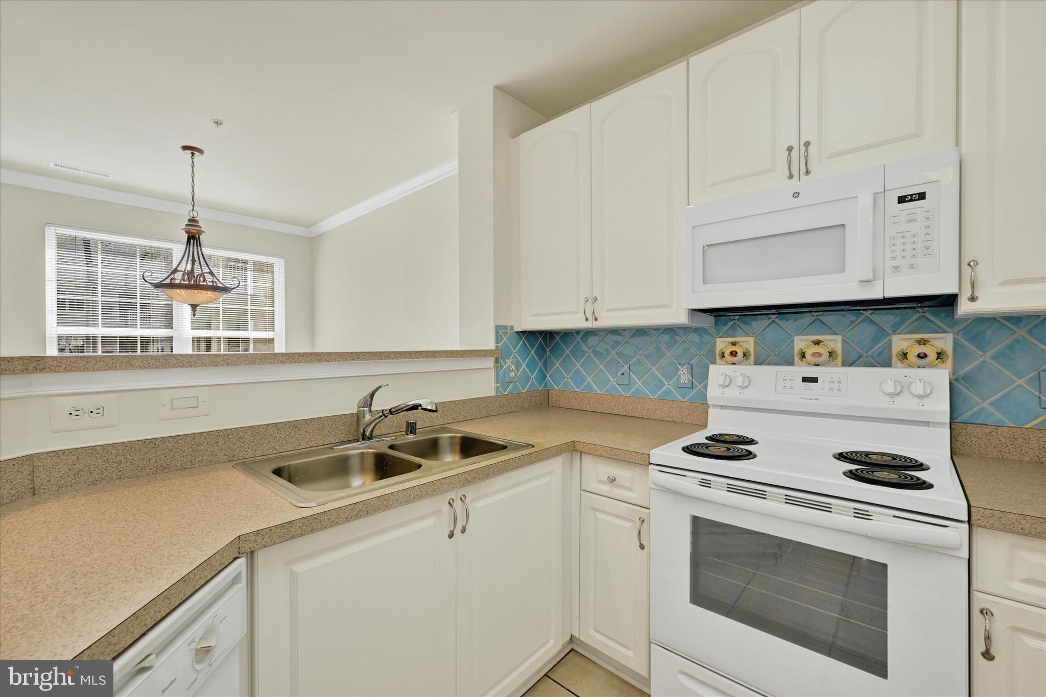 400 Symphony Circle, Unit 414 Hunt Valley, MD 21030 - Photo 7 of 29 a kitchen with granite countertop white cabinets and white appliances