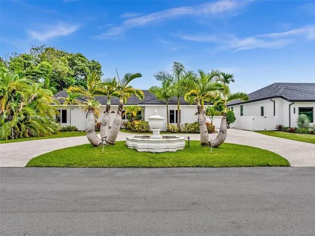 a white house with a yard and plants