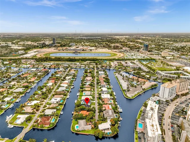 a kitchen with stainless steel appliances kitchen island granite countertop a sink a stove a refrigerator cabinets and chairs