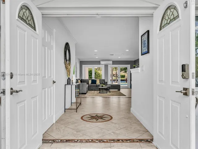 a living room with furniture a refrigerator and kitchen view
