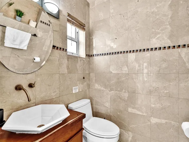 a bed room with a bed a couch and a flat screen tv