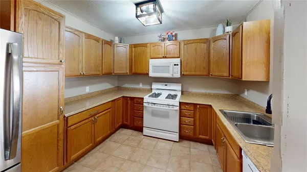 a kitchen with stainless steel appliances granite countertop a refrigerator sink and stove