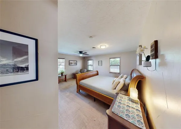 a bedroom with a bed and a painting on the wall