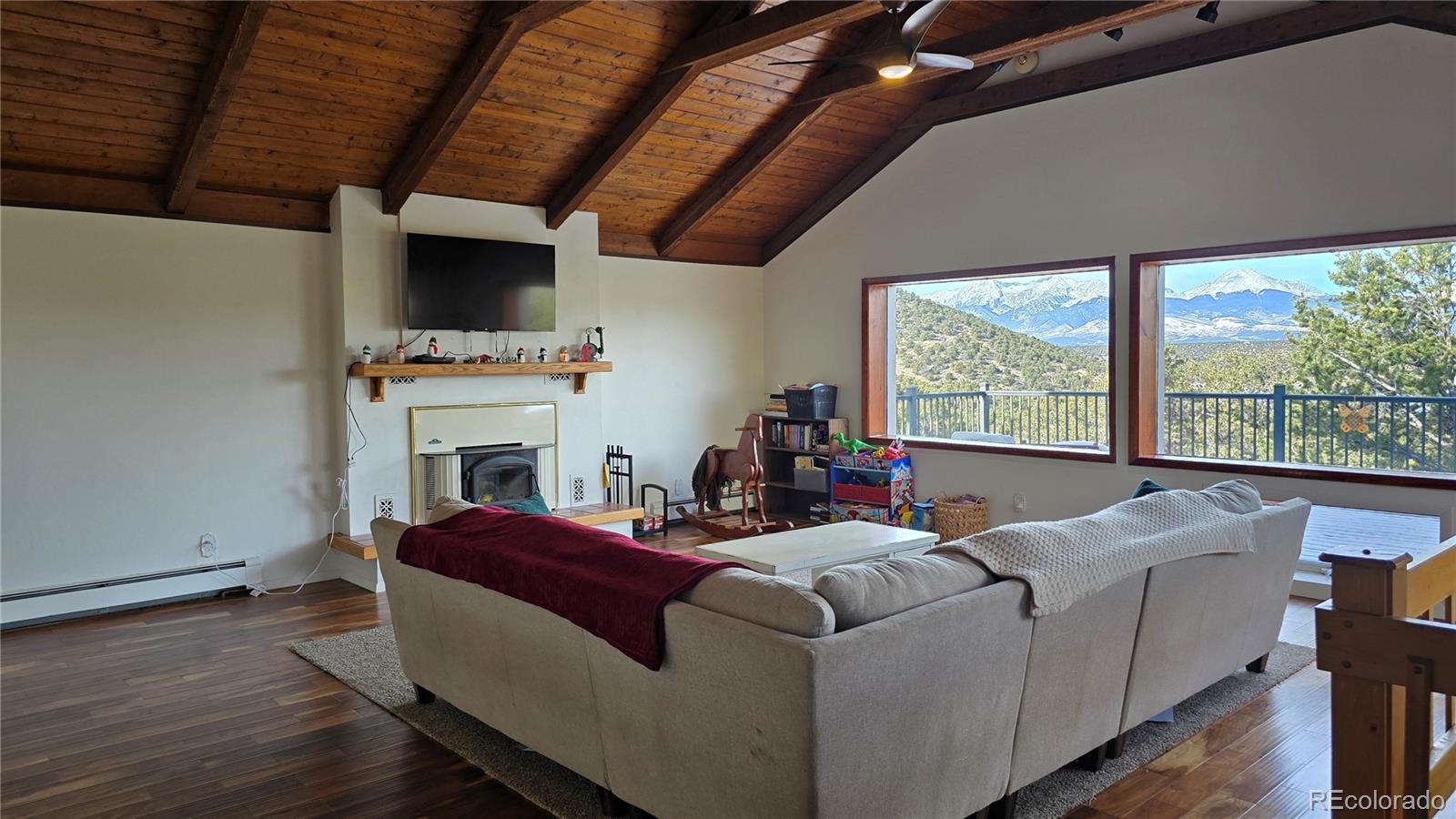 411 Gruenberg Road Fort Garland, CO 81133 - Photo 15 of 41 a living room with furniture a flat screen tv and a fireplace
