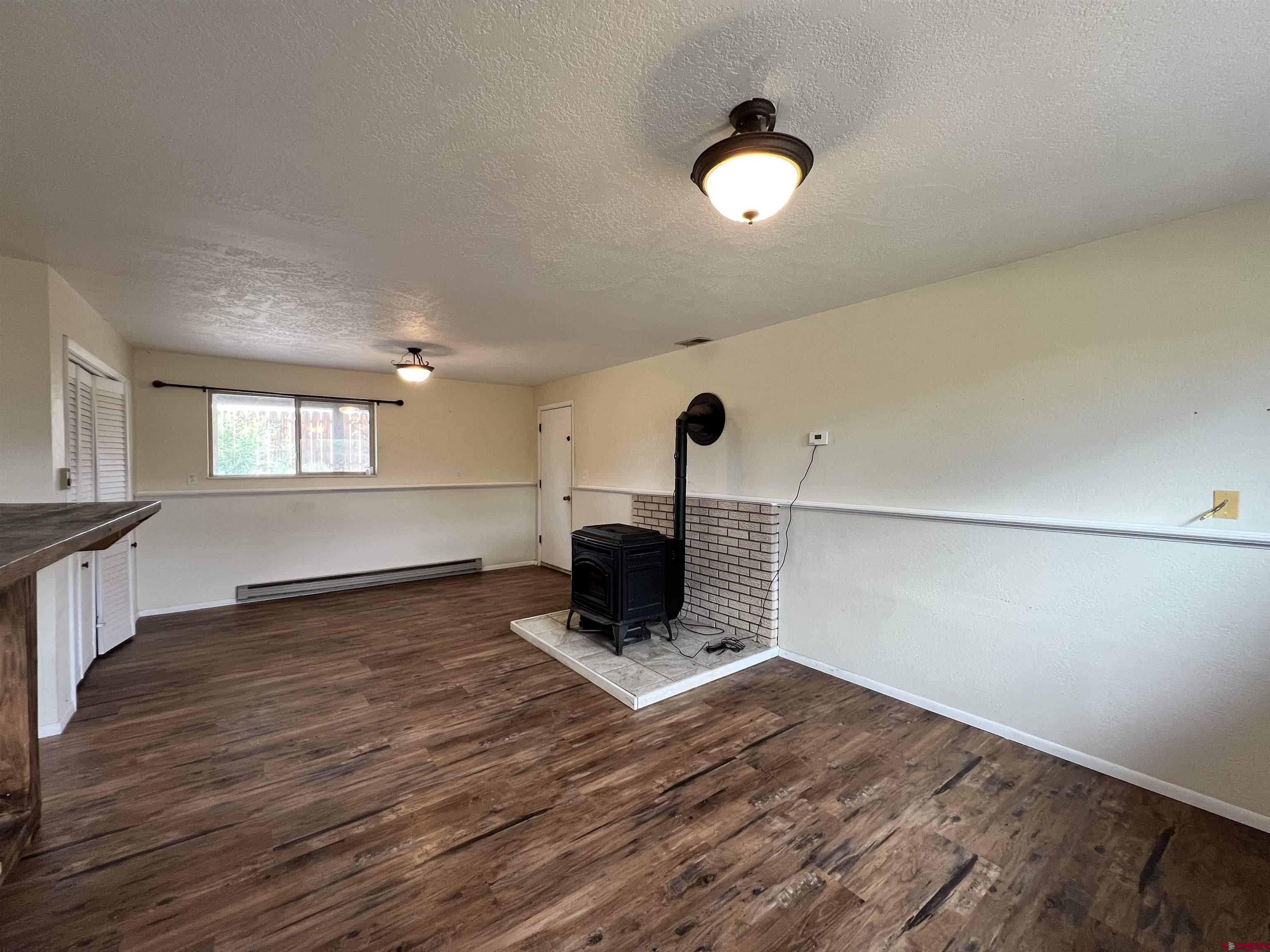 1328 Jackson Street Cortez, CO 81321 - Photo 27 of 37 a view of an empty room with wooden floor and a large window