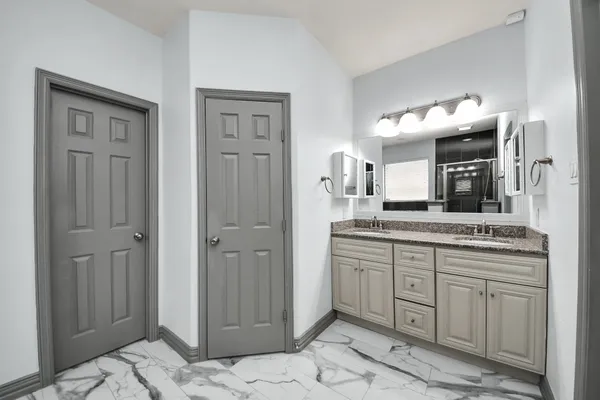 a bathroom with a granite countertop sink and a mirror