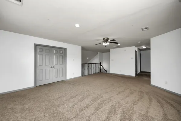 an empty room with closet and windows