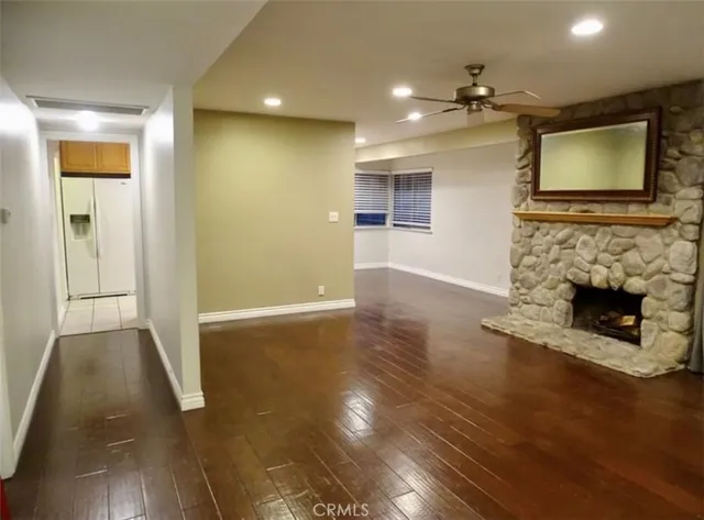 a view of a livingroom with a fireplace a chandelier and wooden floor