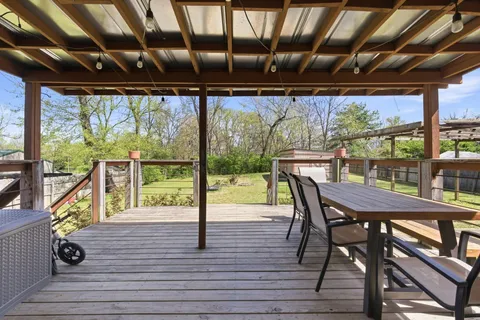 a view of a roof deck with table and chairs and wooden floor
