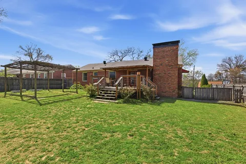 a view of a backyard with a garden and entertaining space