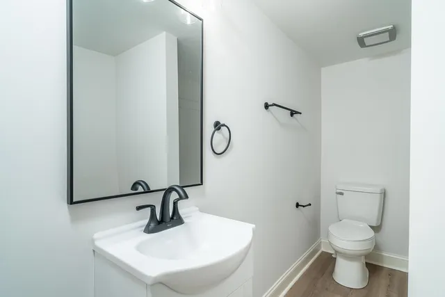 a bathroom with a sink toilet and a mirror